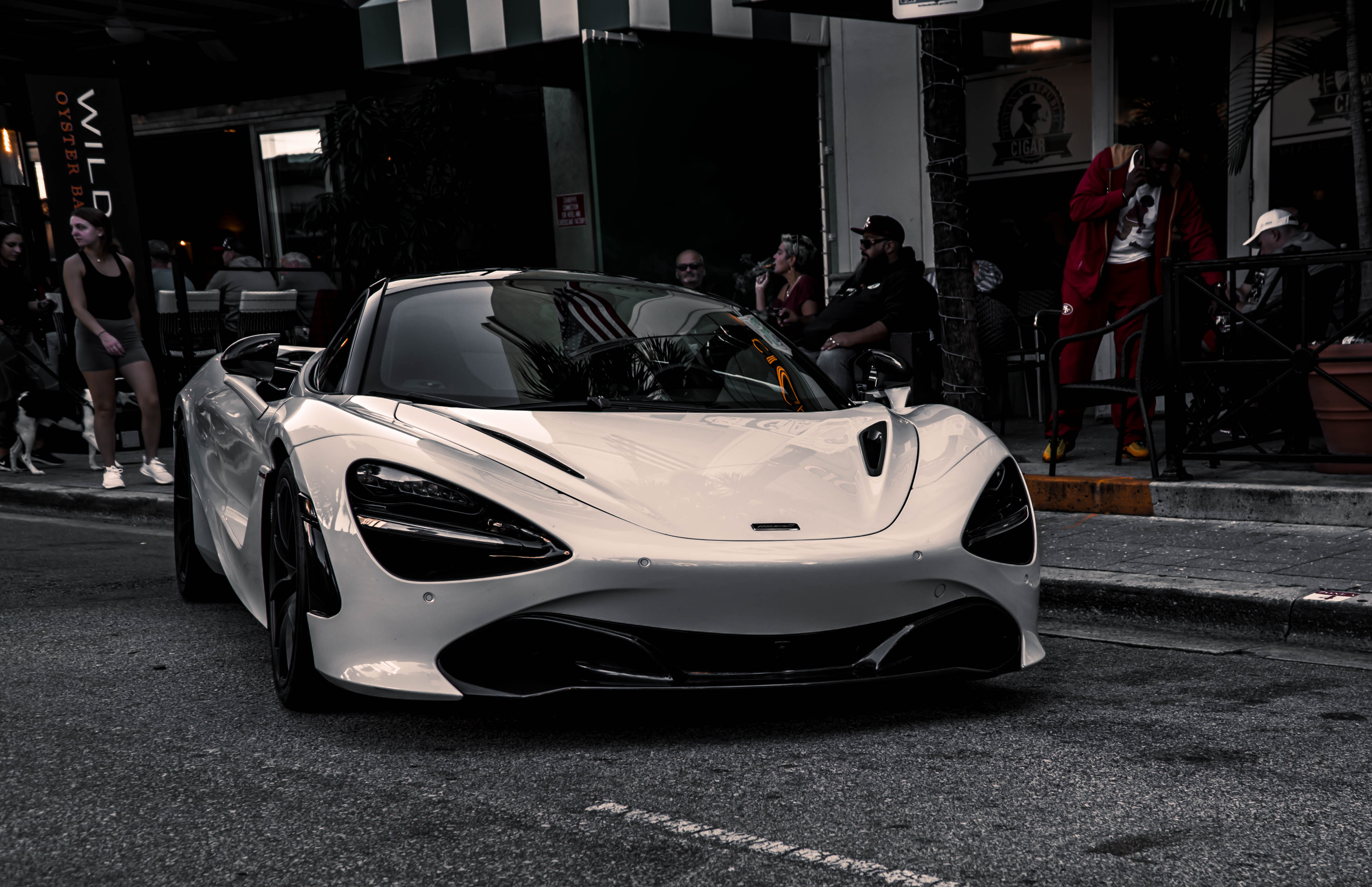 White McLaren 720S on a city street at dusk